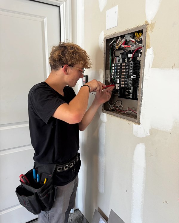 Licensed Amped Up electrician landing a circuit at an open load center