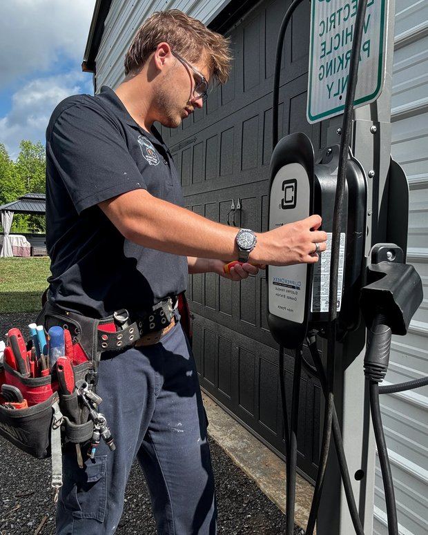 Amped Up electrician commissioning a newly installed Level 2 EV charger at a customer's garage