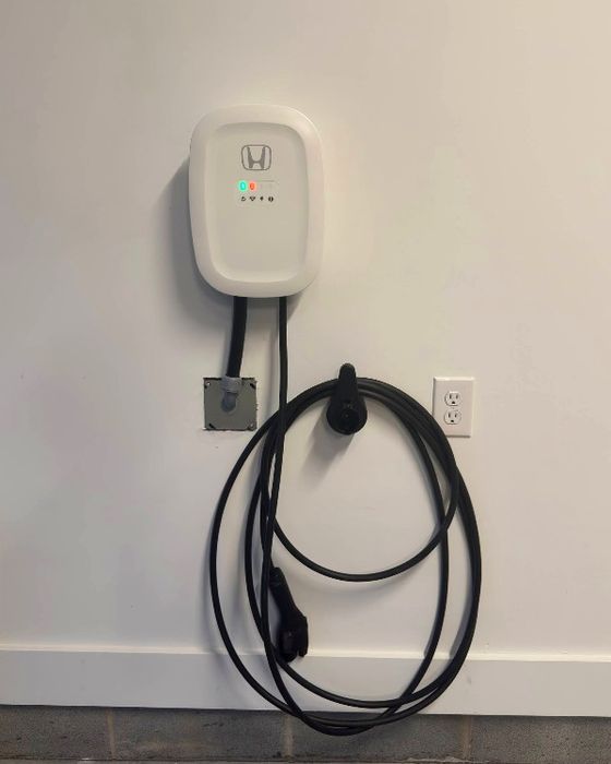Plug-in Level 2 charger cording into the 240V receptacle beside it