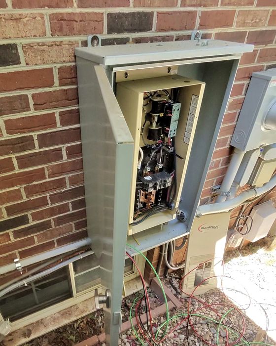 Generator transfer switch wiring in progress on a brick home in the Piedmont Triad by Amped Up Electrical Solutions