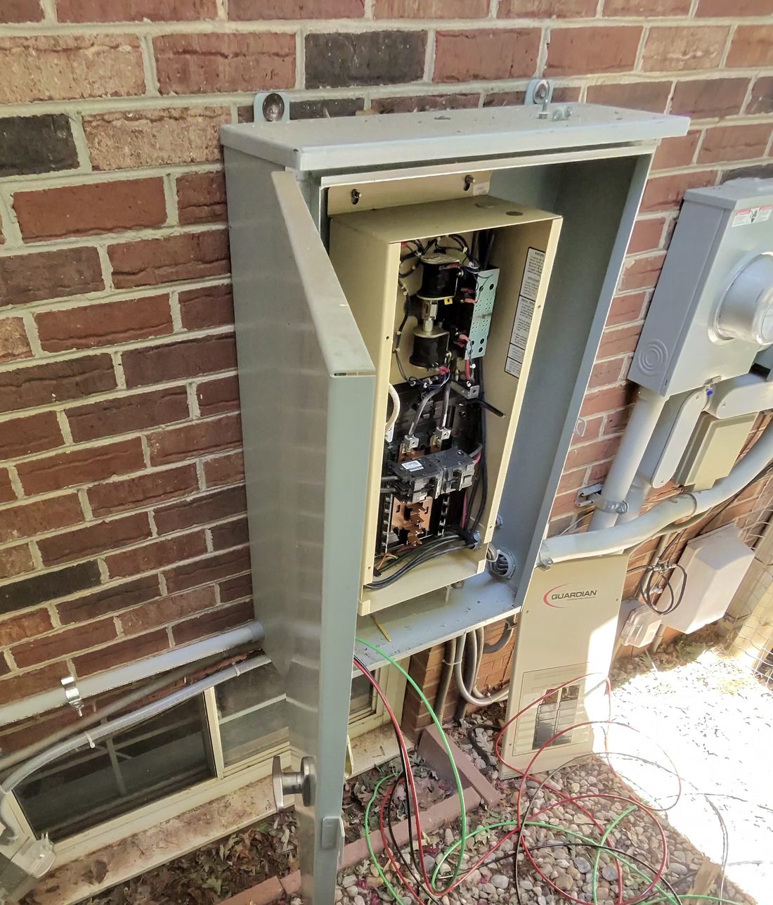 Generator transfer switch wiring in progress on a brick home in the Piedmont Triad by Amped Up Electrical Solutions