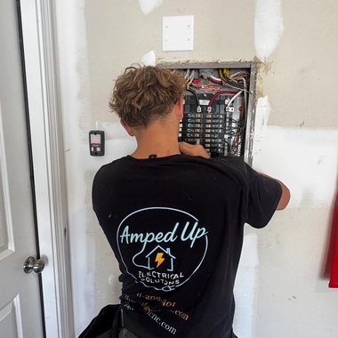 Amped Up electrician working at an open load center on a residential wiring job