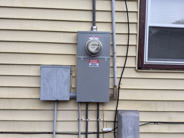 Electric meter base and service disconnect on the exterior wall of a Clemmons, NC home