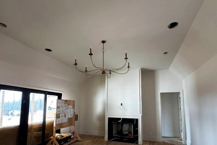Fixture changeout over an open living space with recessed cans in the ceiling