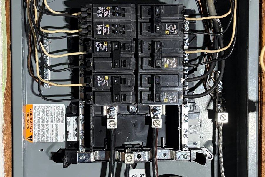 Open residential panel with breakers and branch conductors