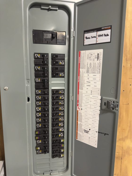 Labelled load center with the deadfront open, breakers seated and the circuit directory filled in