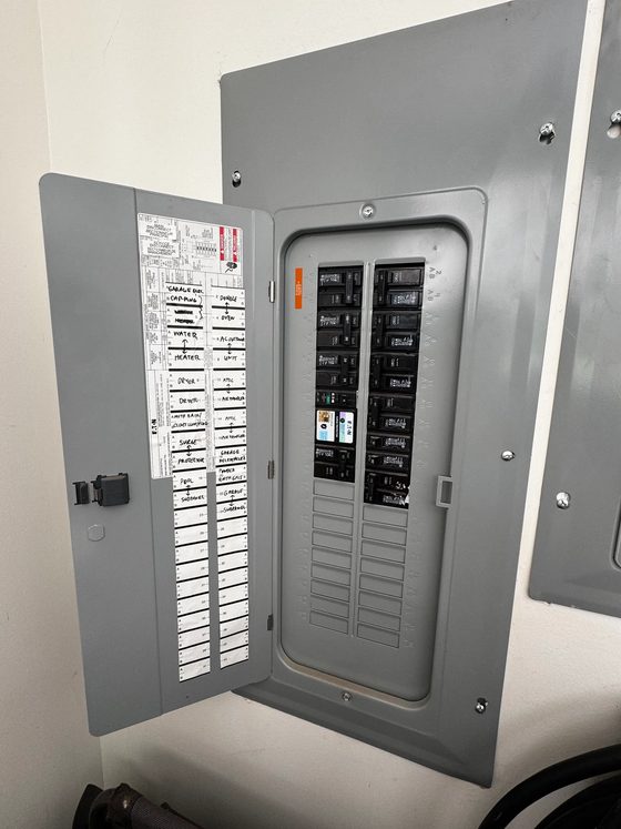 Open load center with every branch circuit hand-labelled on the door schedule