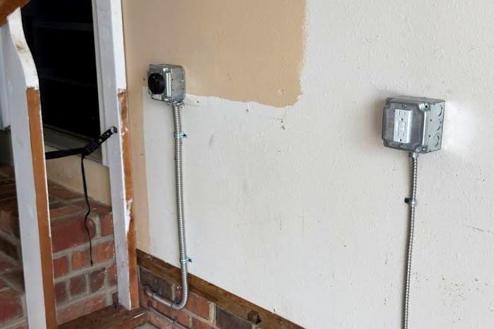 New outlets and conduit run on an interior wall during a rewire