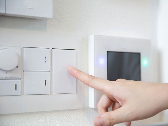 Finger pressing a smart lighting keypad on a wall